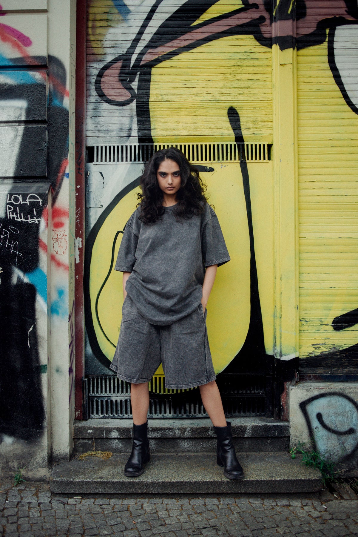 Model wearing the WebZero acid wash shorts and matching tee on a Berlin street